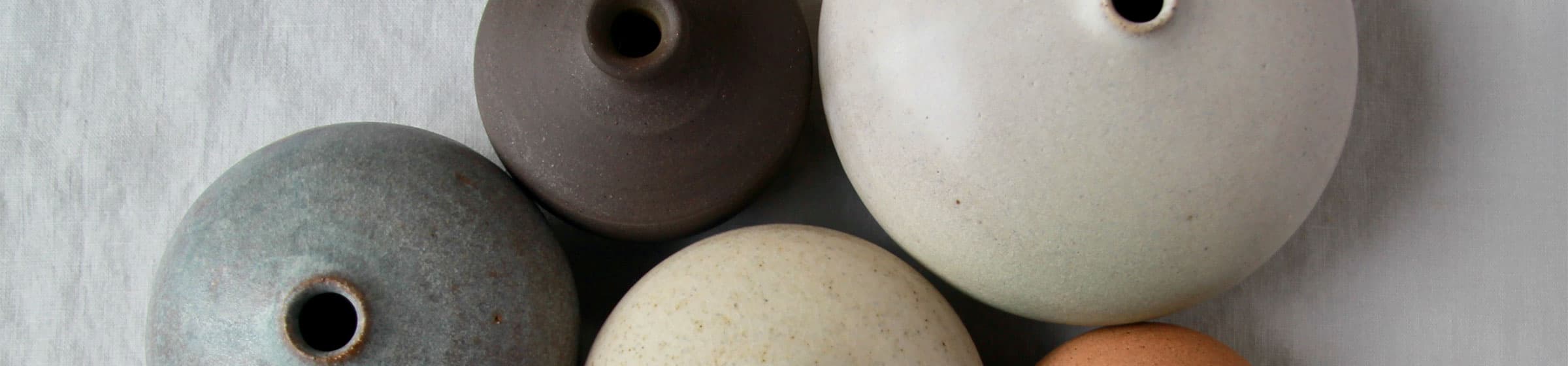 Close-up of an array of different coloured ceramic vases.